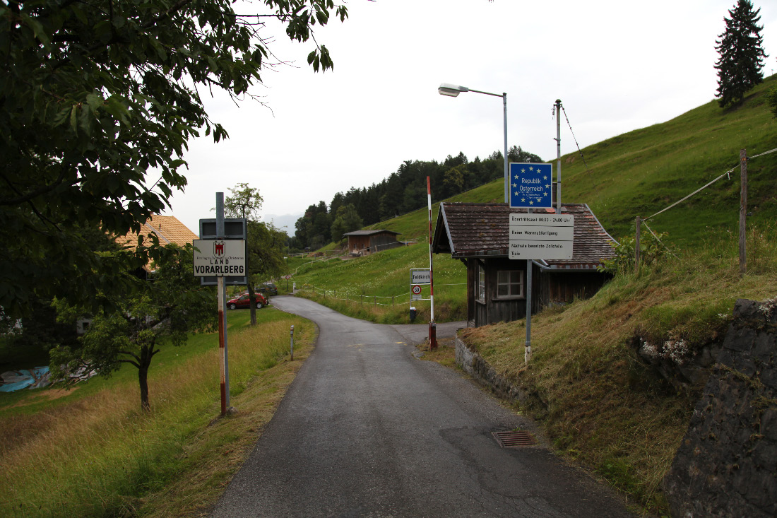 On St. Georg-Straße in the Schällabärg – Schellenberg Gemeinde of northeast Liechtenstein and looking at open road, as should be the case within European Christendom, a very few meters ahead to Fresch in Austria – Österreich