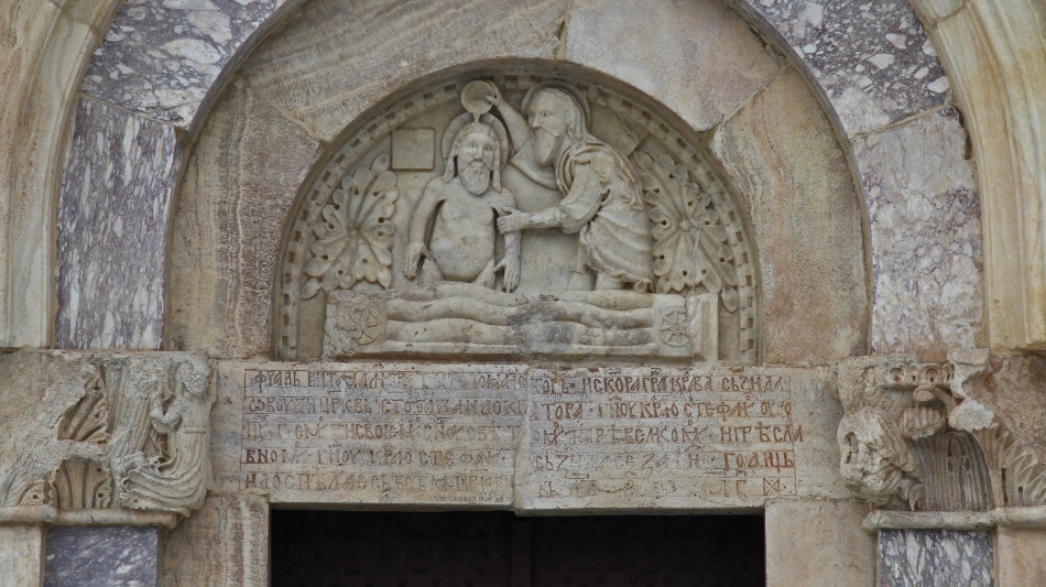 tympanum of John the Baptist baptizing Christ Jesus and lintel thanking Catholic Franciscan monk and architect Fra Vita